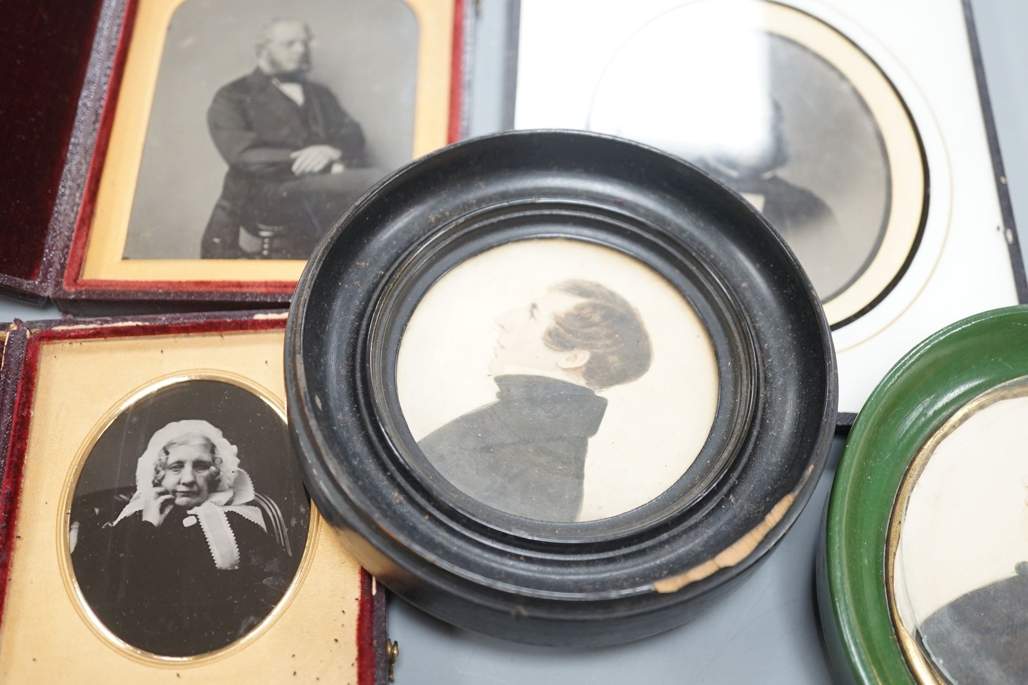 A collection of Victorian photographs etc including a tinted daguerreotype, three portrait miniatures and cabinet cards